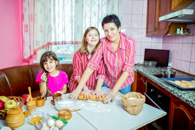 special woman with caregiver and child baking