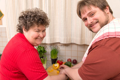a mentally disabled woman and a young man cooking together