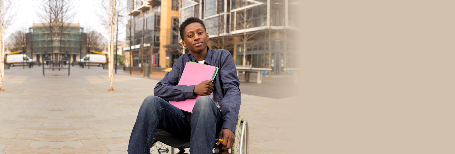 young man in a wheelchair holding documents